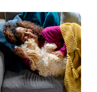 A pet parent snuggling with a pet dog