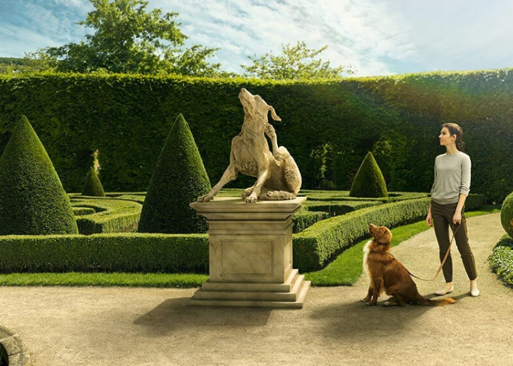 dog and owner admiring a dog shaped statue
