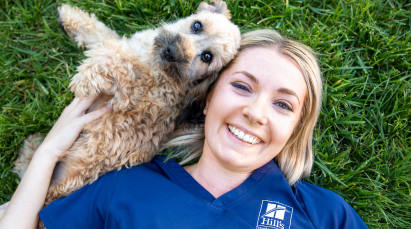 Employée Hill’s allongée dans l'herbe avec un chien