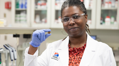 Employée Hill's tenant dans sa main une croquette pour animaux de compagnie